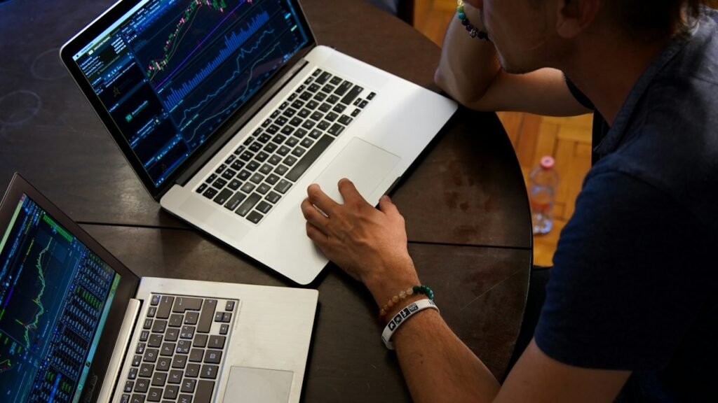 Investor reviewing portfolio data on a laptop while weighing AI stock market correction risk