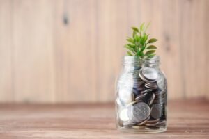 passive income ideas jar of coins with growing plant representing money growth