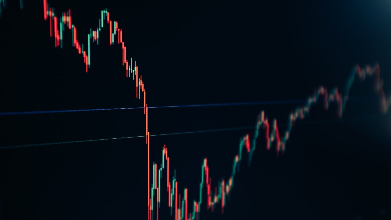 Candlestick stock chart on a dark screen, the market view behind an option spread