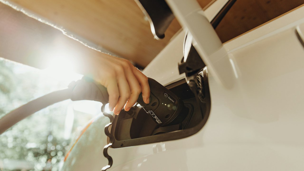 Charging cable plugged into an electric vehicle, representing the Rivian stock forecast