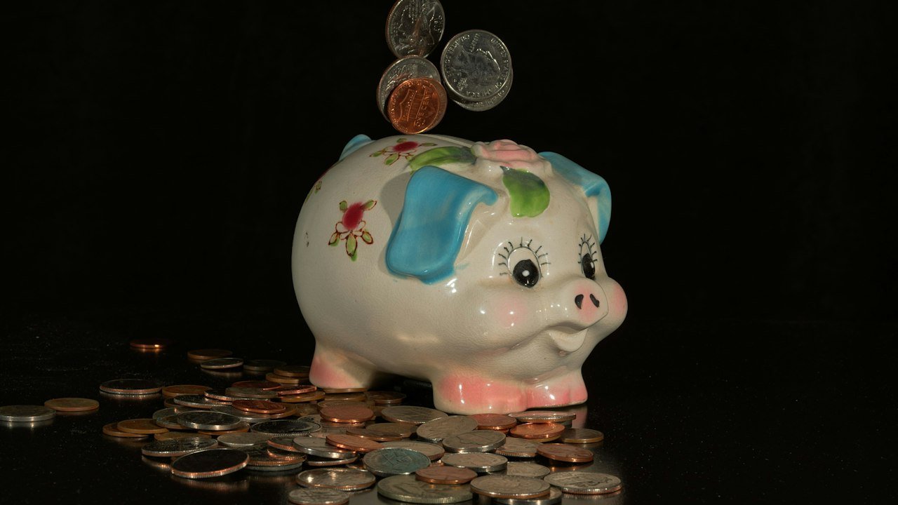 Coins falling into a piggy bank to show savings earning high yield savings account rates