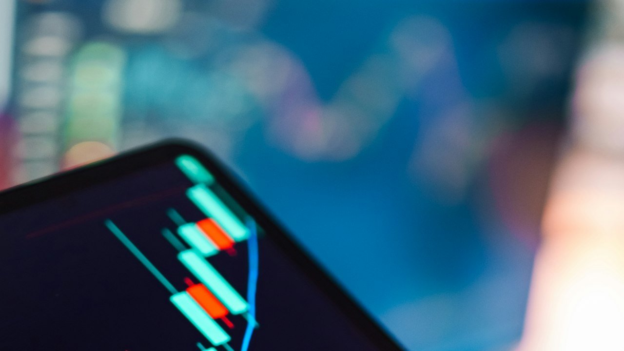 Crypto or stocks for beginners: tablet showing a stock candlestick chart