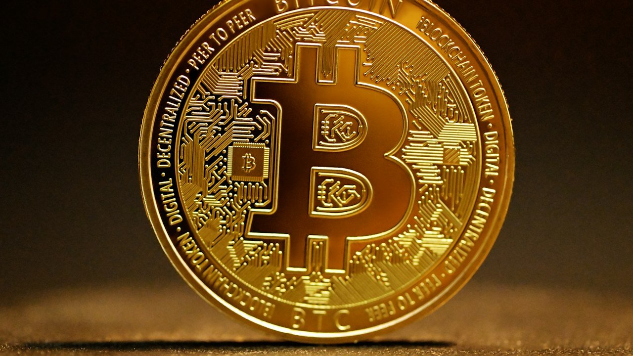 Golden bitcoin coin on a table representing bitcoin ETF inflows