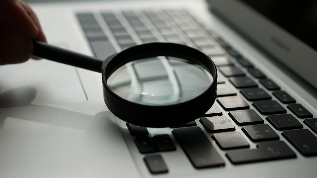 Magnifying glass beside a laptop representing research with Perplexity Pro
