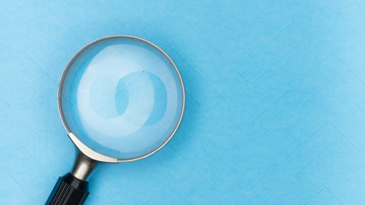 Magnifying glass on a table, checking a tokenoid crypto project before trusting it