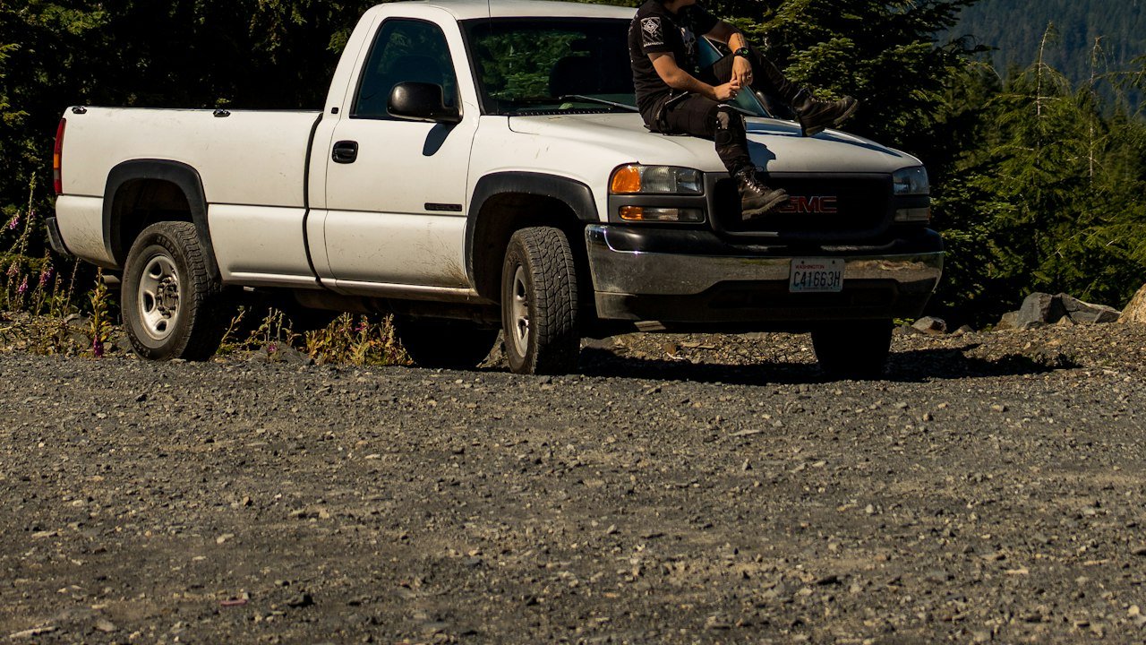 Man sitting on a pickup truck in a forest, the outdoor buyers behind the Rivian stock forecast