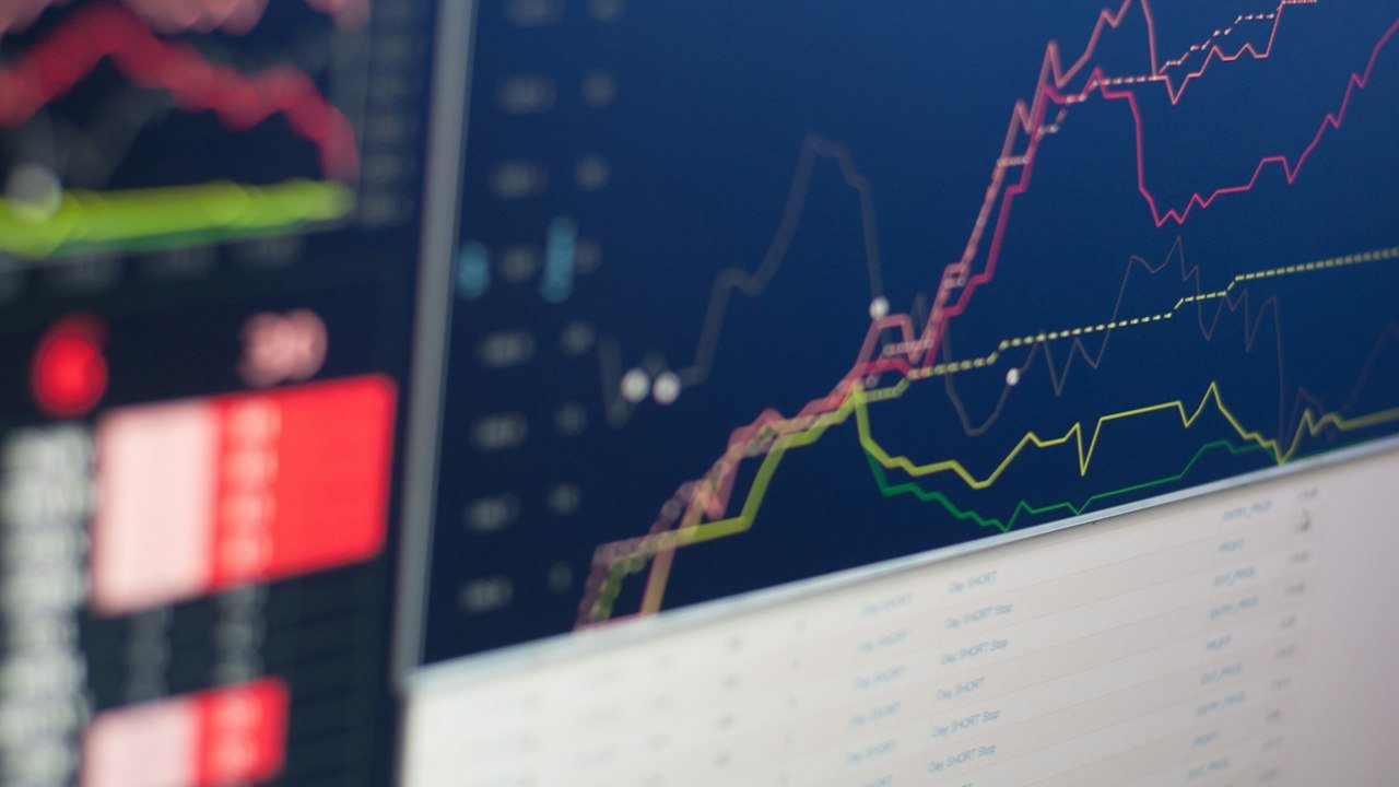 Monitor showing a market graph as stocks react to the Fed rate hike 2026