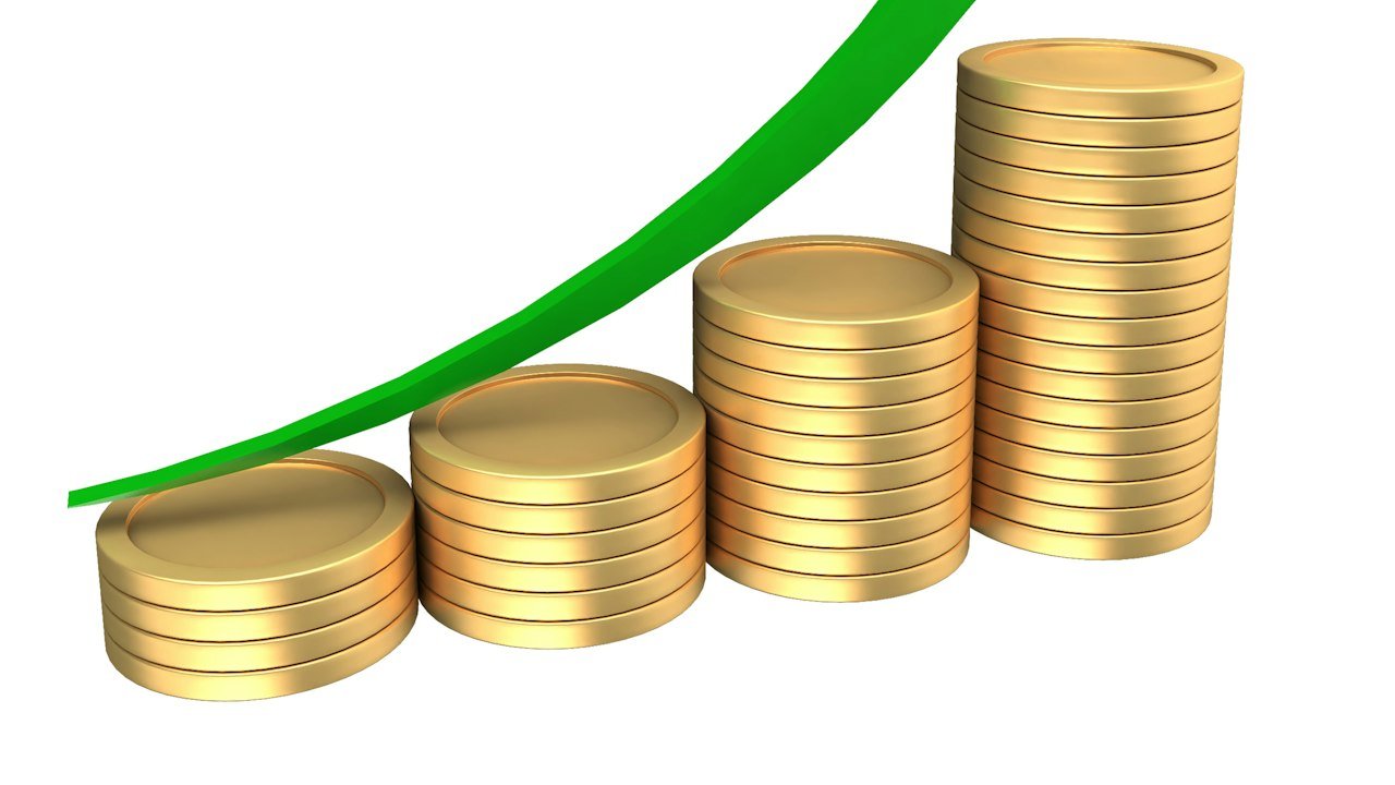 Multibagger stocks: stacks of coins with a rising green arrow