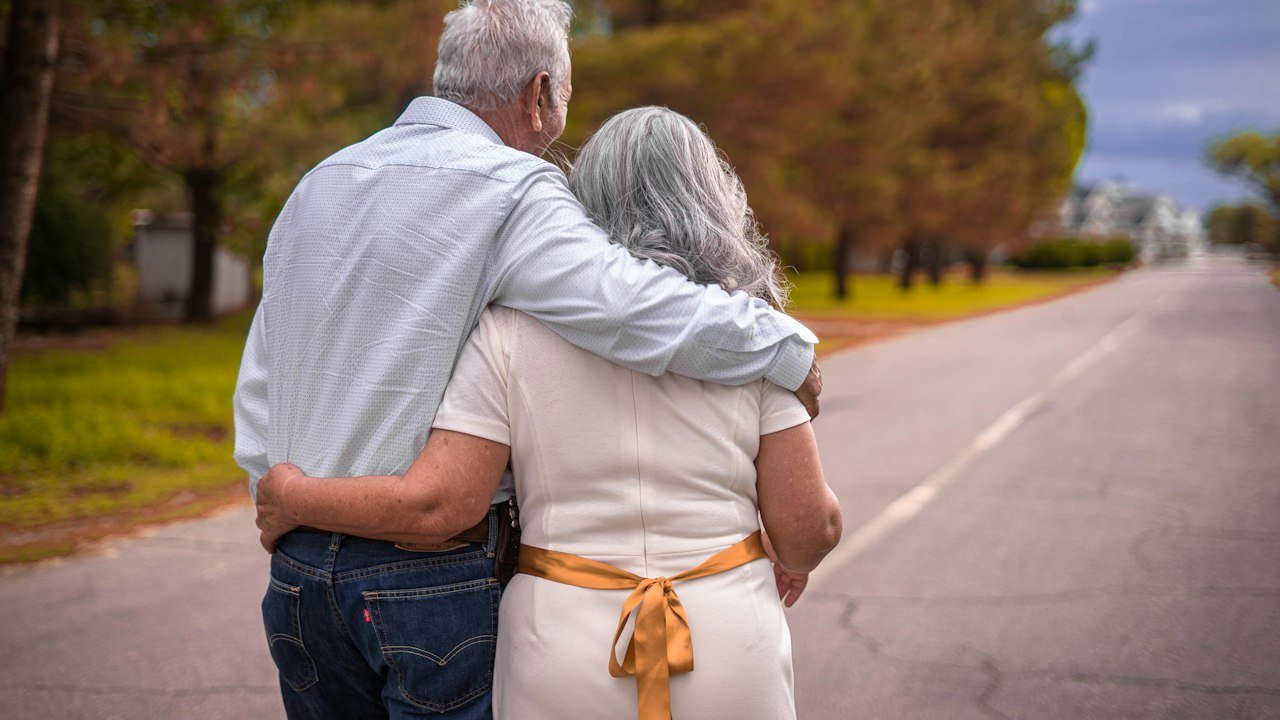 Older couple walking arm in arm, planning around 2027 retirement contribution limits