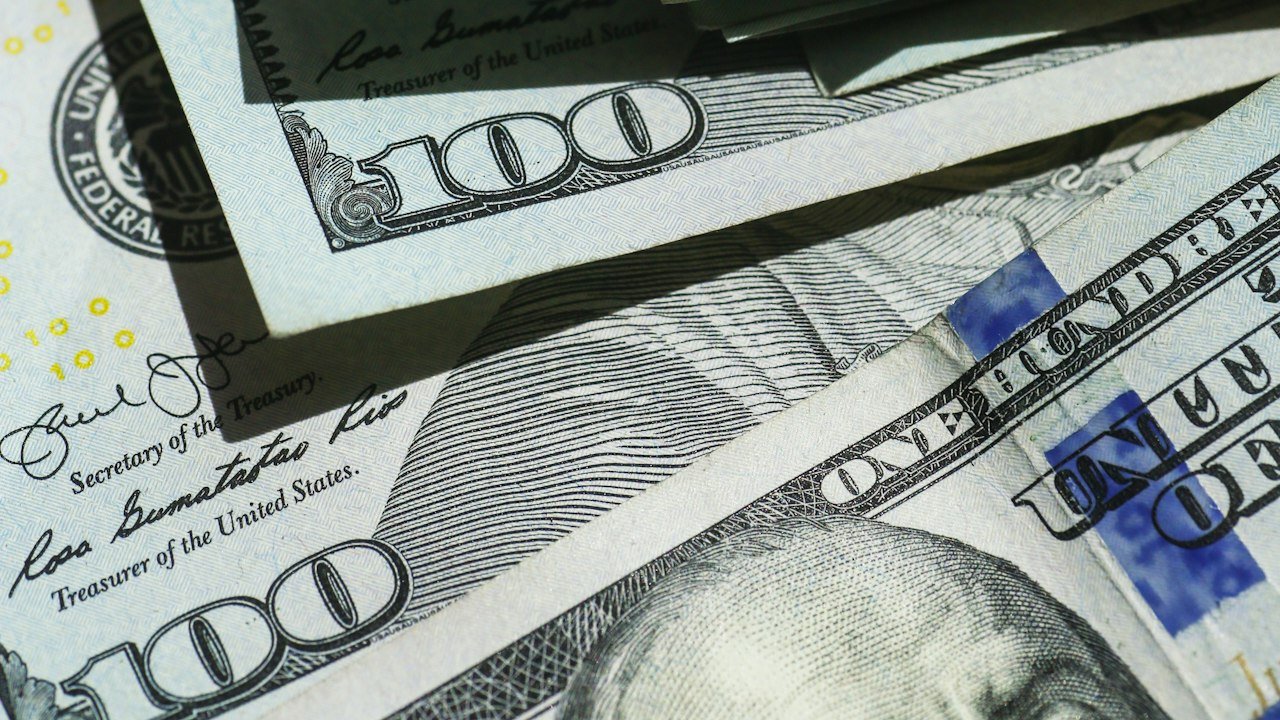 Stacked hundred dollar bills illustrating the Fed rate hike 2026 and higher borrowing costs