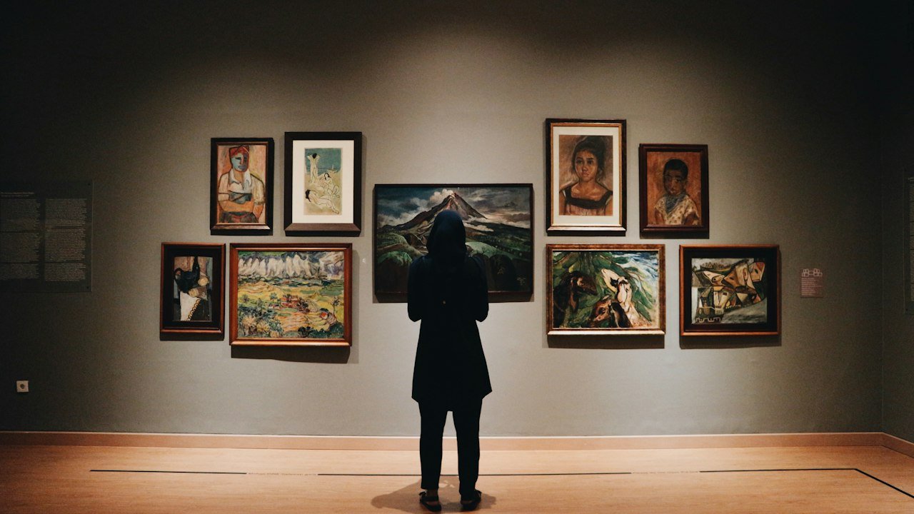 Visitor in front of framed artworks, a physical comparison for nft collections