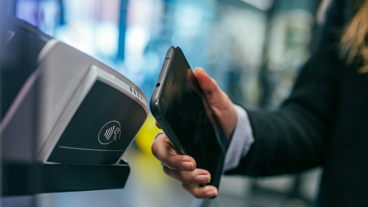Woman holding a smartphone to pay with a digital wallet such as the digital rupee
