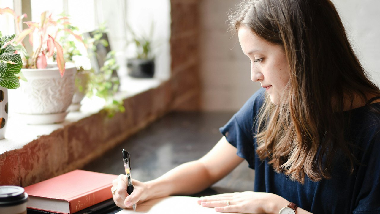 Woman writing a budget and plan before she starts investing in stocks